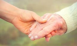 2 mani che si toccano relative a una badante e la persona che assiste